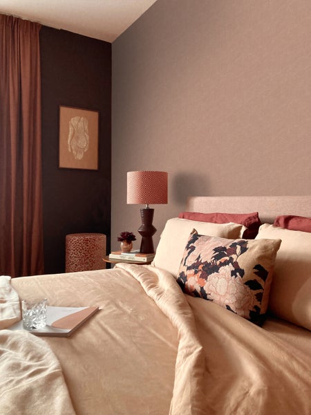 Schlafzimmer mit Bett, Nachttischlampe und dekorativen Elementen für eine gemütliche Atmosphäre