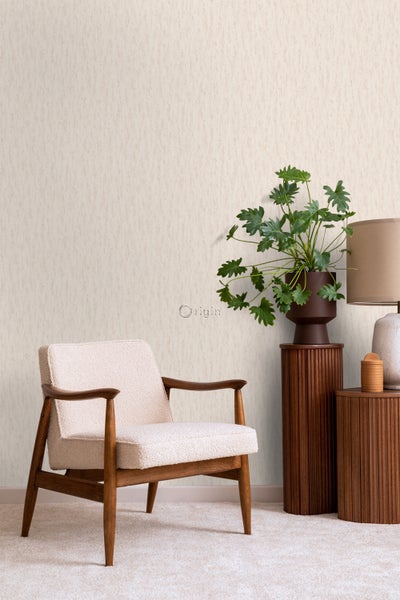 Heller Raum mit strukturierten Tapeten, Sessel und dekorativen Beistelltischen mit Pflanze und Lampe