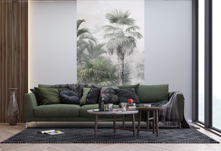 Wohnzimmer mit grüner Couch, Couchtisch und Wandbild mit Palmen