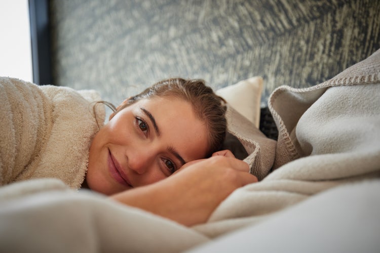 Ecksauna mit Glastür in hellem Holzdesign in einem hellen Raum.