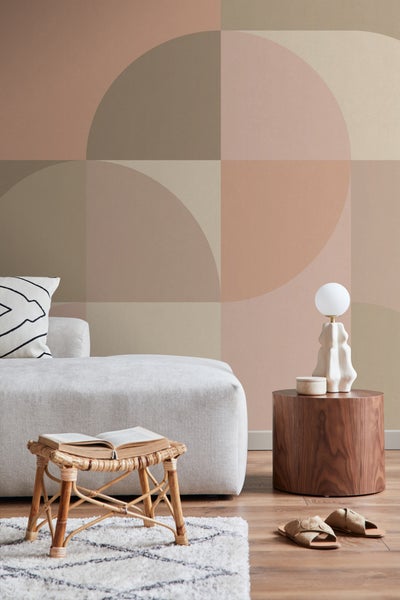 Wohnzimmer mit Sofa, Lampe und geometrischer Tapete