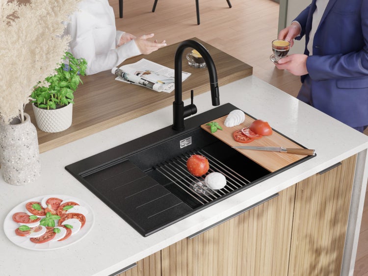 Küchenszene mit Spüle, Armatur, Schneidebrett und Zutaten für Caprese