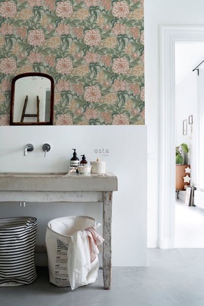 Badezimmer mit Waschbecken aus Beton, Spiegel und floraler Tapete