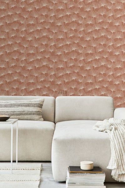 Wohnzimmer mit dekorativer Tapete mit Gingko-Blatt-Motiv hinter einem Sofa.