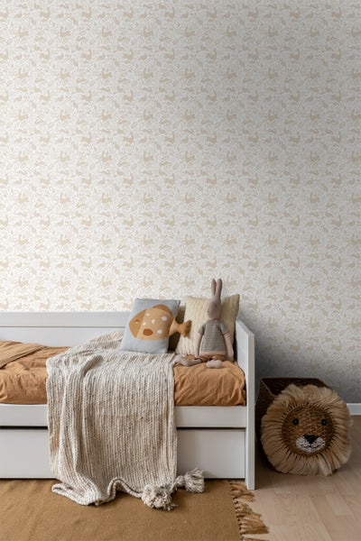 Kinderzimmer mit weißem Bett, Dekokissen, Kuscheltier, Tagesdecke, Teppich und Tapete mit Tiermotiv