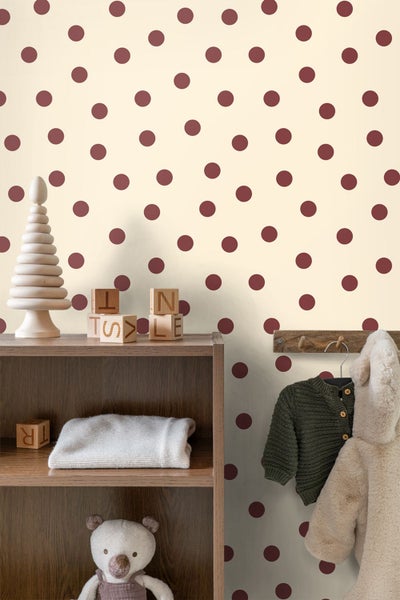 Vliestapete mit Punktemuster in einem hellen Kinderzimmer mit Holzregal, Holzspielzeug und Kinderkleidung an der Wand.
