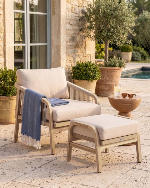 Moderner Gartenmöbel-Set mit Holzsessel, Seildetails und passendem Hocker auf einer hellen Terrasse an einem Swimmingpool.