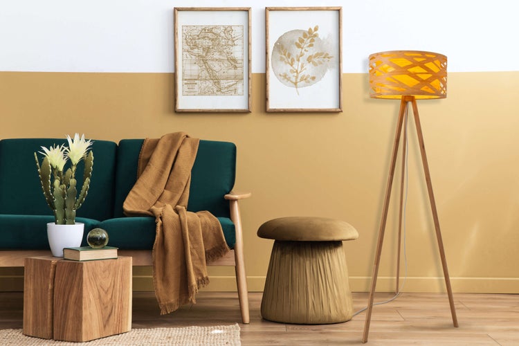 Wohnzimmer mit Sofa, Stehlampe, Hocker und Dekorationen für eine gemütliche Atmosphäre.