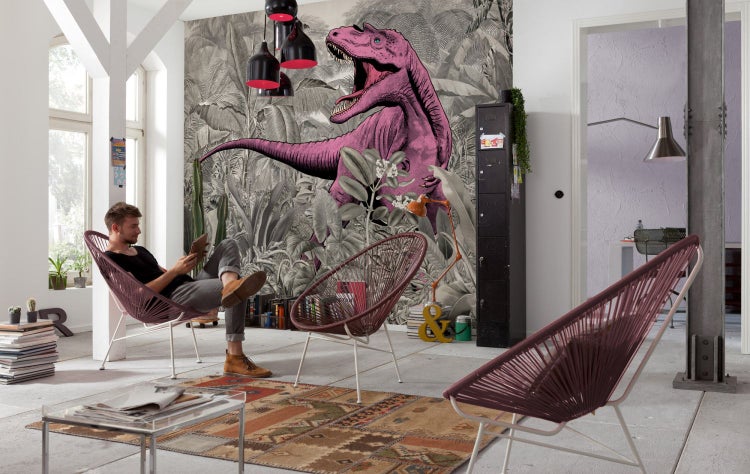 Wohnzimmer mit Mann in einem Sessel vor einer Fototapete mit Dinosaurier-Motiv.