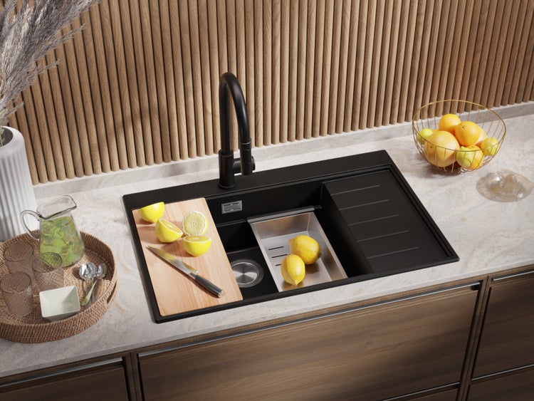 Küchenszene mit schwarzer Spüle, Schneidebrett mit Zitronen und Armatur