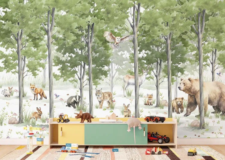 Kinderzimmer mit Wald-Fototapete, die Tiere wie Bär, Hirsch und Eule zeigt, sowie Holzmöbeln wie Regal, Tisch und Stühlen.