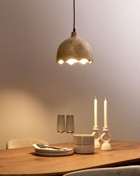 Esstisch-Szene mit Keramik-Hängeleuchte, Geschirr, Gläsern und Kerzenhaltern.