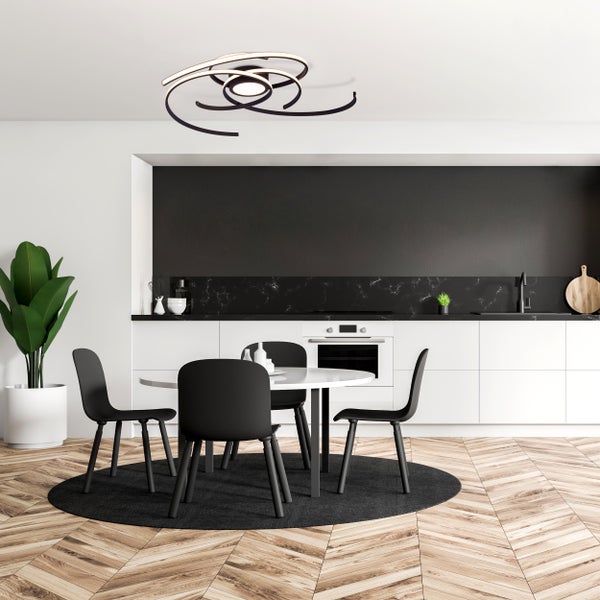Esszimmer mit Esstisch, Stühlen und spiralförmiger Deckenleuchte