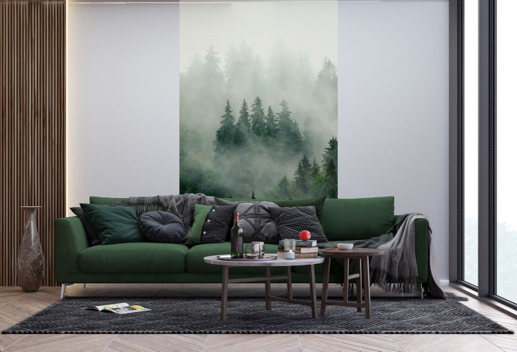 Wohnzimmer mit grünem Sofa, Couchtisch und Waldtapete