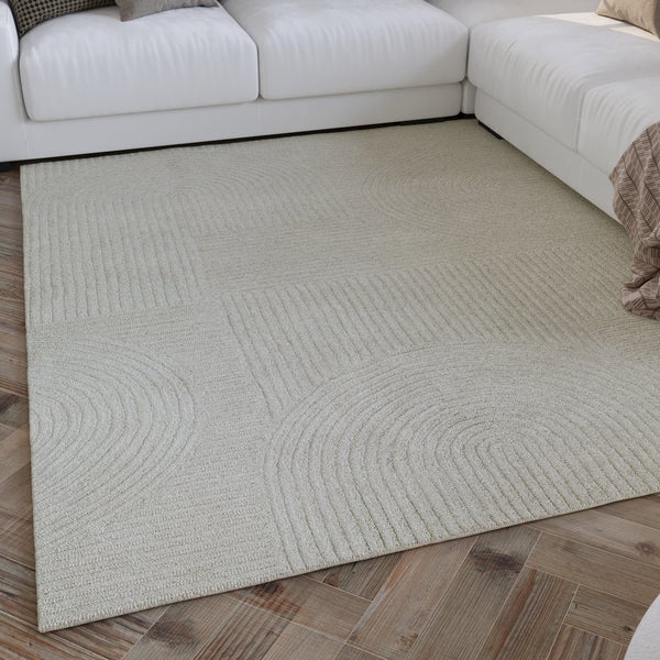 Moderner Teppich mit geometrischem Reliefmuster in einem hellen Wohnzimmer vor einem weißen Sofa auf Holzfußboden.