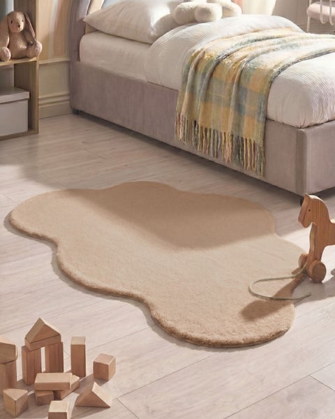 Weicher, wolkenförmiger Plüschteppich in einem gemütlichen Kinderzimmer mit Holzspielzeug, einem Bett und hellem Holzboden.