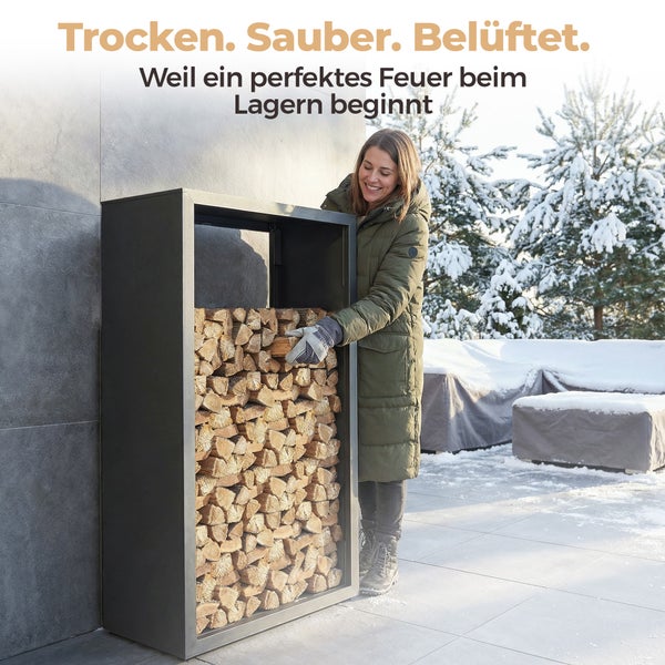 Frau entnimmt Brennholz aus einem Brennholzregal im Wintergarten