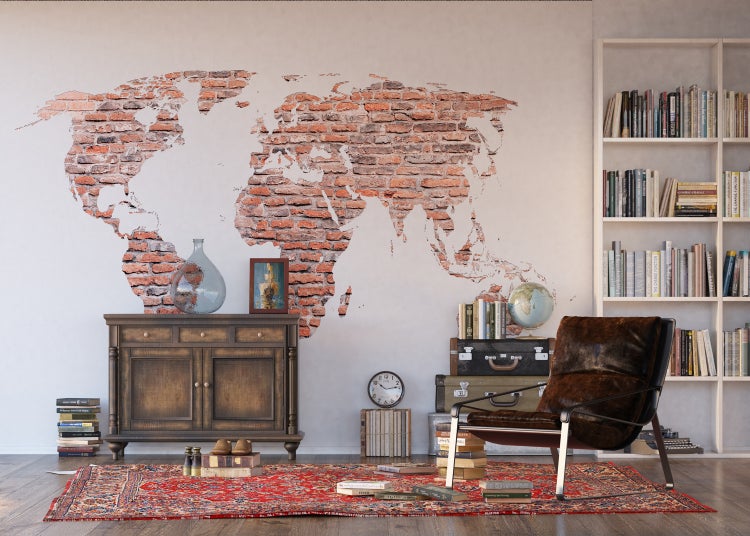 Wohnzimmer mit Karte aus Ziegelsteinen an der Wand, Kommode, Sessel und Bücherregal