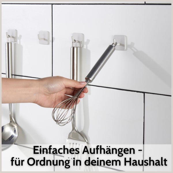 Selbstklebende Wandhaken in der Küche zum Aufhängen von Küchenutensilien aus Edelstahl an einer Fliesenwand.