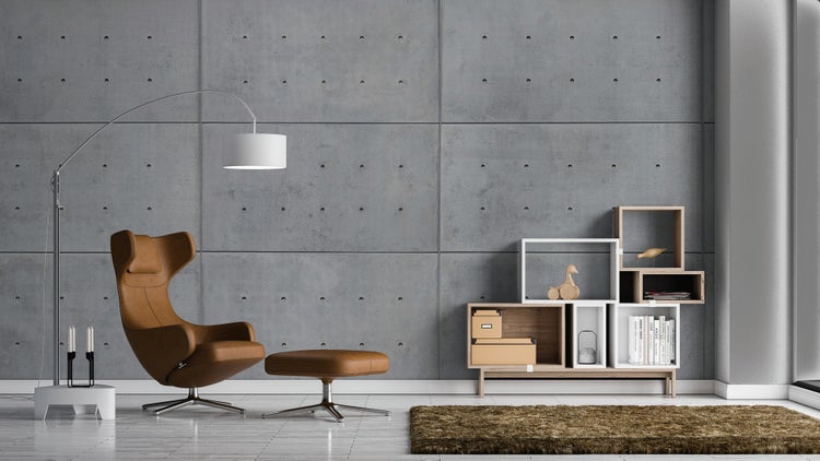 Modernes Wohnzimmer mit Wandpaneelen in Betonoptik, Leder-Relaxsessel mit Hocker, Bogenstehleuchte und modularem Regal.