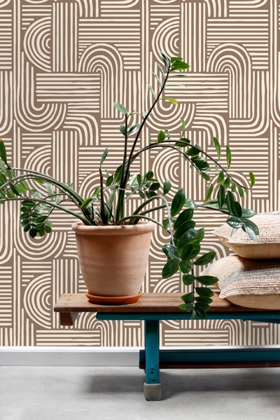 Dekorative Tapete mit geometrischem Muster, kombiniert mit Zimmerpflanze und Kissen auf einer Bank