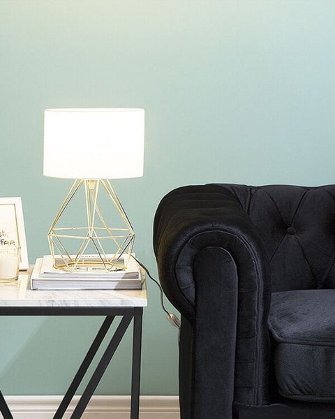 Szene mit Tischleuchte, Tisch und Sofa