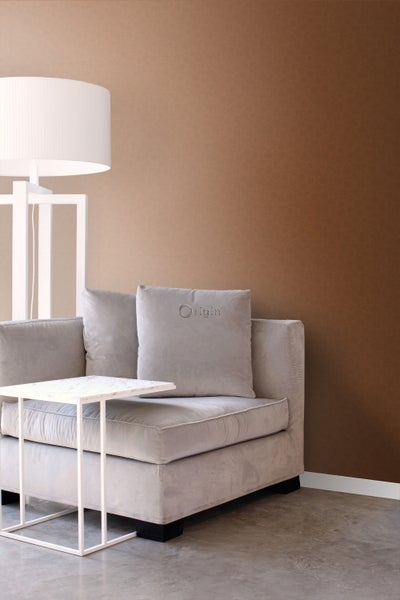 Wohnzimmer mit beigem Sofa, Beistelltisch und Stehlampe vor gemusterter Wand