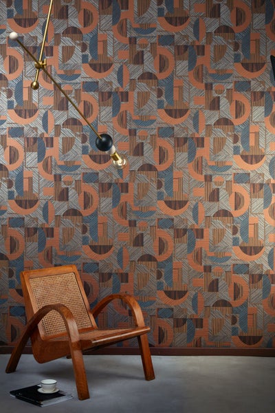 Innenraum mit gemusterter Tapete in geometrischen Formen hinter einer Sitzecke