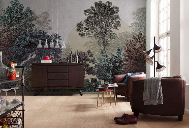Wohnzimmer mit Kommode, Sesseln und Fototapete mit Waldmotiv für eine natürliche Atmosphäre