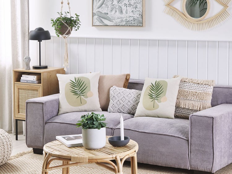 Wohnzimmer mit Sofa, Kissen und Beistelltisch aus Holz