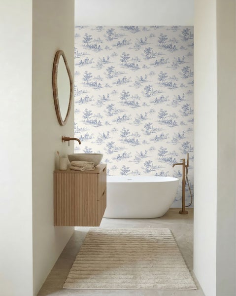 Helles, modernes Badezimmer mit freistehender Badewanne, Holzwaschtisch mit Steinwaschbecken und blau-weißer Toile-de-Jouy-Tapete.