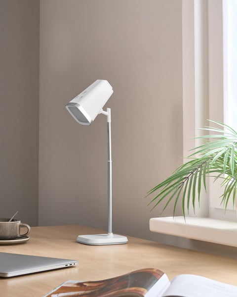 Moderne Stehlampe aus Metall und Kunststoff auf einem Schreibtisch