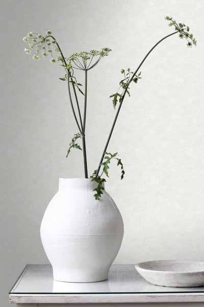 Dekorative weiße Vase mit Blumen auf einem Tisch