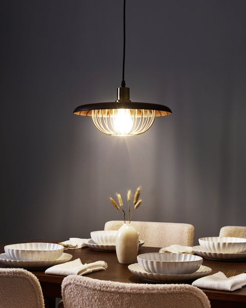 Esstisch mit Gedeck unter einer Hängelampe für eine stimmungsvolle Atmosphäre
