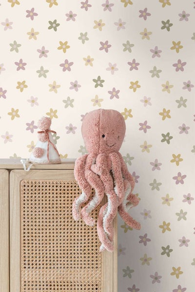 Kindertapete mit Blumenmuster vor einem Rattan Schrank mit einem Stofftier Oktopus und einer Dekofigur im Kinderzimmer.