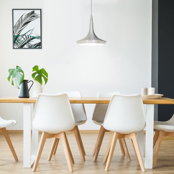 Esstisch mit Stühlen, Hängeleuchte und Dekoration in einem hellen Raum