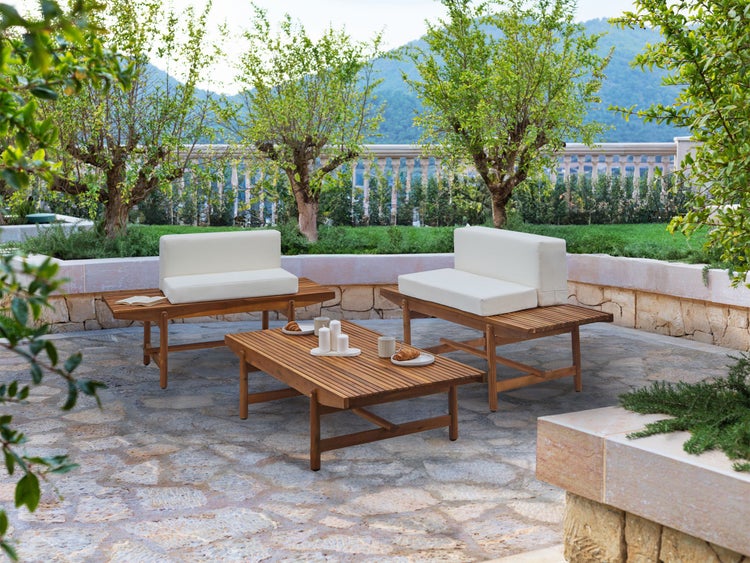 Gartenmöbel-Set mit Holztisch und Sofas mit Auflagen in einem Garten