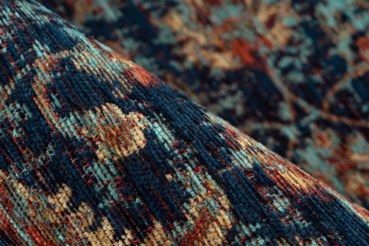 Detailaufnahme eines gewebten Teppichs mit Vintage-Muster in Blau und Orange.