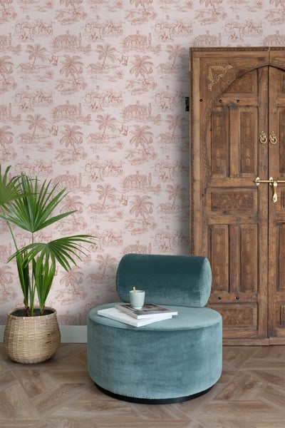 Raumansicht mit Tapete mit Tiermotiven, blaugrünem Sessel und Holztür