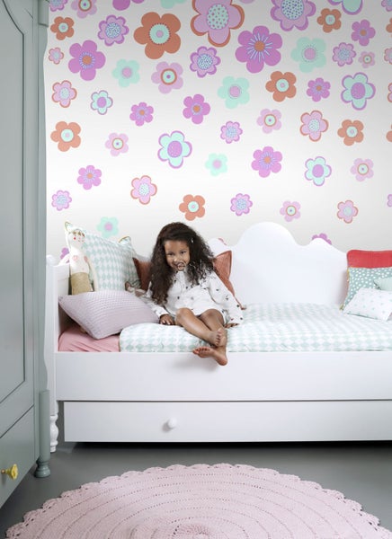 Kinderzimmer mit Blumenmustertapete, Bett und Mädchen