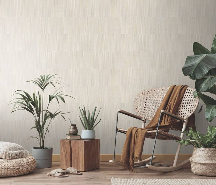 Wohnraum mit gemusterter Tapete, Schaukelstuhl und Zimmerpflanzen für eine natürliche Atmosphäre