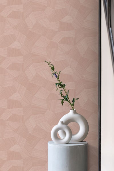 Tapete mit geometrischem Polygonmuster und feiner Struktur, davor zwei weiße kreisförmige Keramikvasen mit einem Pflanzenzweig auf einem Sockel.