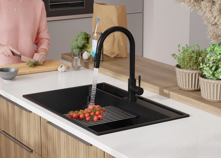 Küchenszene mit Spüle, Wasserhahn, Gemüse und Person beim Kochen