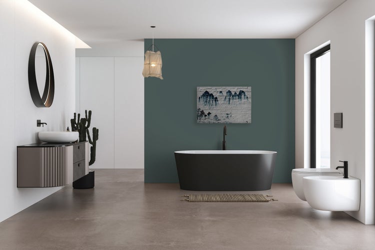 Modernes Badezimmer mit freistehender Badewanne, wandhängendem Waschbecken, Toilette und Bidet vor einer Wand in dunklem Salbeigrün.