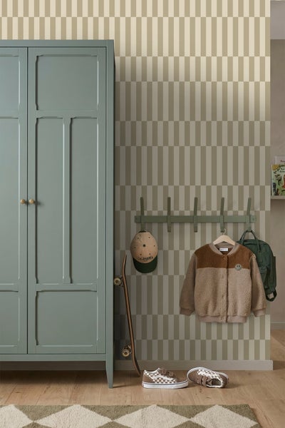 Tapete mit geometrischem Muster in einem Zimmer mit grünem Holzschrank, Garderobenleiste und Skateboard auf Holzboden.