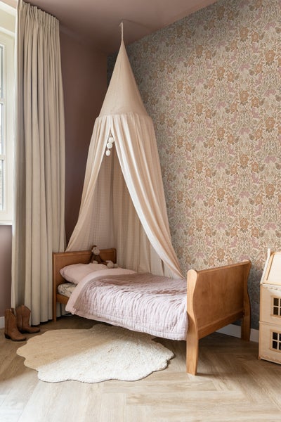 Kinderzimmer mit Himmelbett, gemusterter Tapete und Teppich