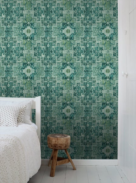 Schlafzimmer mit gemusterter Tapete in Blau- und Grüntönen