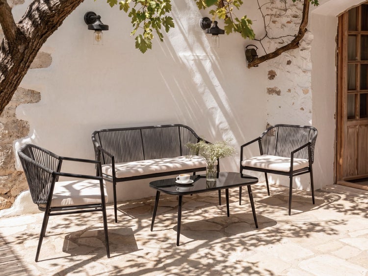 Garten-Lounge-Set aus Metall und Seilgeflecht mit Sofa, Sesseln und Tisch auf einer Steinterrasse in sonniger Atmosphäre.
