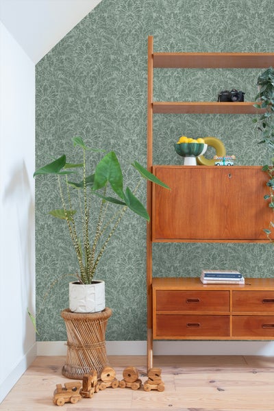 Gemusterte Tapete im Wohnraum mit Holzregal und Zimmerpflanze.