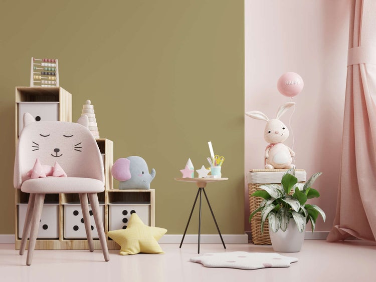 Hell eingerichtetes Kinderzimmer mit einer zweigeteilten Wandgestaltung in Olivgrün und Pastellrosa sowie Holzmöbeln und Spielzeug.